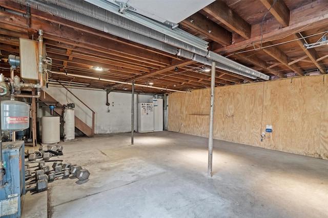 basement with wooden walls and water heater