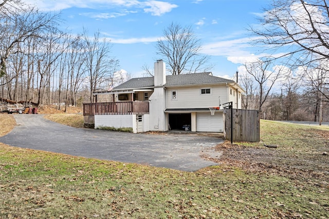 rear view of house with a yard and a garage