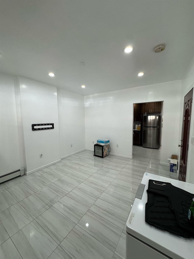 interior space featuring recessed lighting, a baseboard heating unit, and baseboards