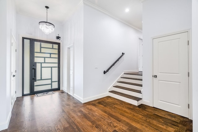 foyer with an inviting chandelier, ornamental molding, and dark hardwood / wood-style floors