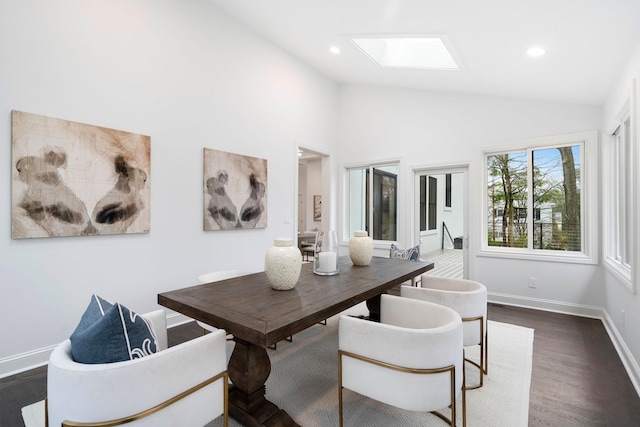 dining room with dark wood-type flooring and vaulted ceiling with skylight