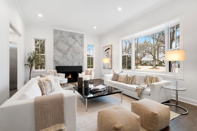 living room with crown molding, a high end fireplace, and wood-type flooring