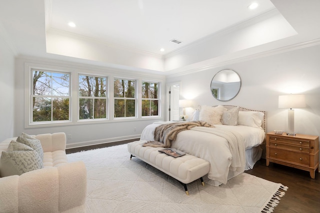 bedroom with a raised ceiling, ornamental molding, and dark hardwood / wood-style flooring