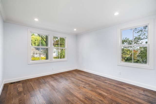 empty room featuring dark wood-type flooring and ornamental molding