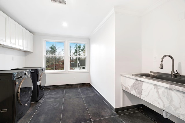 clothes washing area with cabinets, ornamental molding, dark tile patterned flooring, and washer and clothes dryer