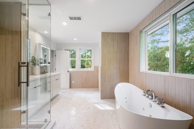 bathroom with vanity, plus walk in shower, and tile walls