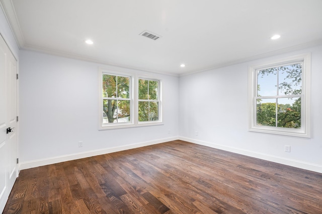 spare room with dark hardwood / wood-style flooring and crown molding