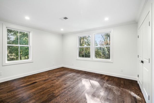 empty room with dark hardwood / wood-style flooring and ornamental molding