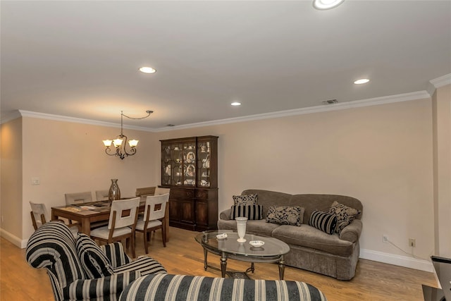 living room with ornamental molding, light hardwood / wood-style floors, and a chandelier