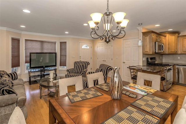 dining room with ornamental molding, light hardwood / wood-style flooring, and a chandelier