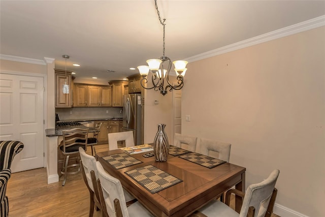 dining room featuring a chandelier, light hardwood / wood-style floors, and ornamental molding