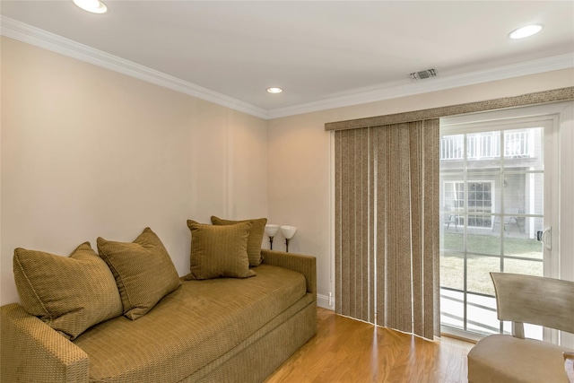 living room with ornamental molding and light hardwood / wood-style floors