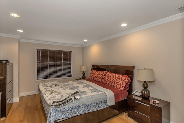 bedroom with ornamental molding and light hardwood / wood-style flooring