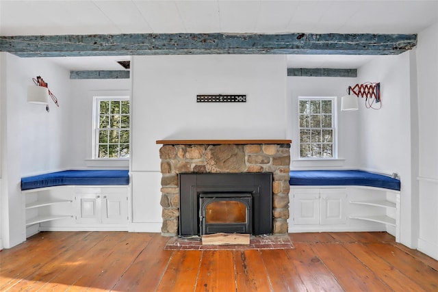 unfurnished living room featuring hardwood / wood-style flooring, beamed ceiling, and a wealth of natural light