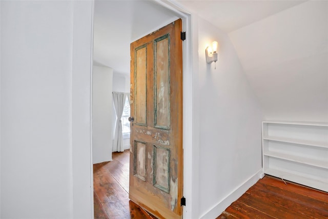 hall with hardwood / wood-style floors and lofted ceiling