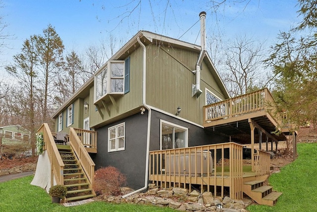 back of house with a deck and a yard