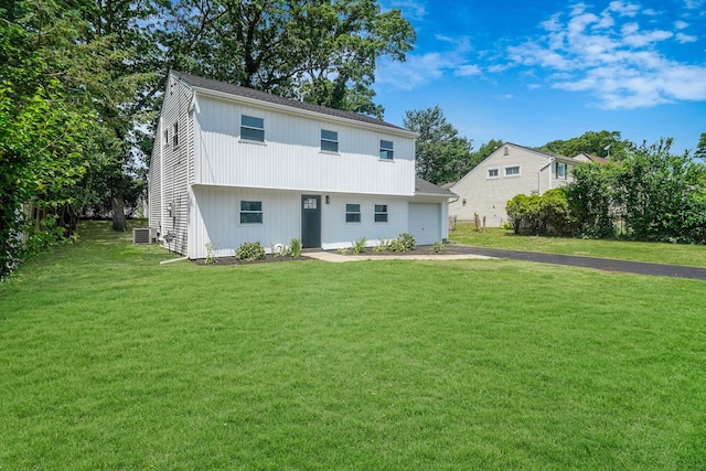 rear view of house with a yard and a garage