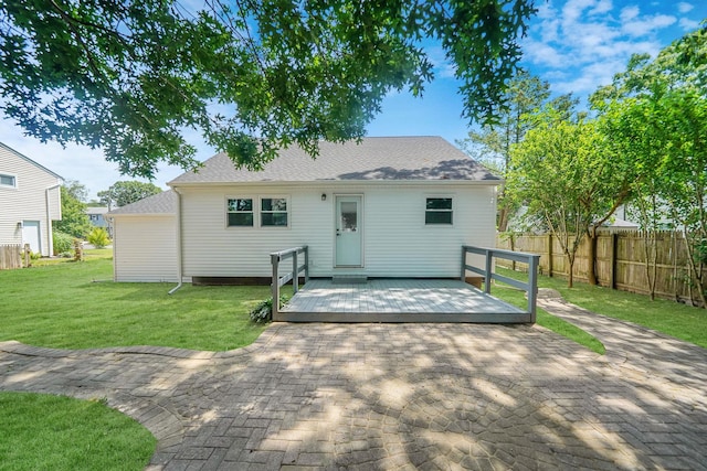 back of property with a lawn and a wooden deck