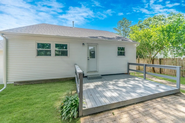 rear view of house featuring a lawn and a deck