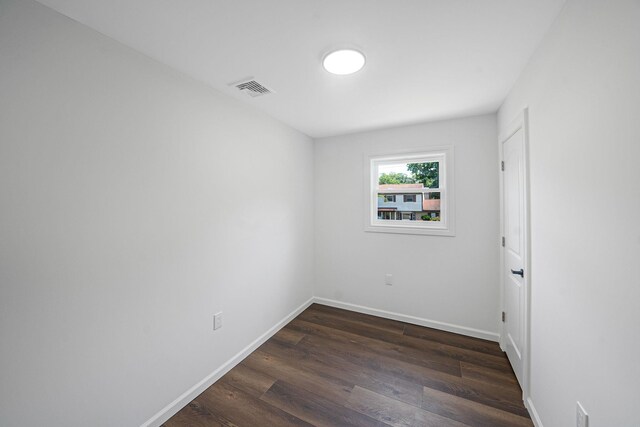 unfurnished room with dark wood-type flooring