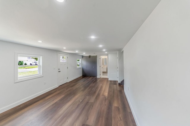 interior space featuring a barn door and dark wood-type flooring