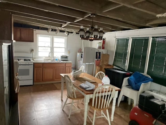 kitchen featuring white appliances, a notable chandelier, and sink