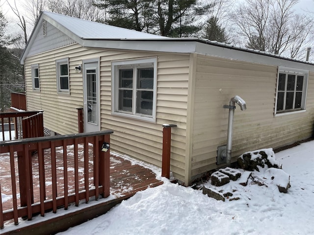 snow covered property featuring a wooden deck