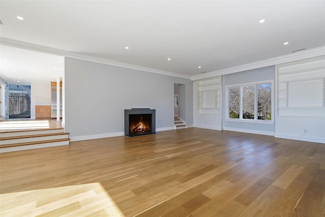 unfurnished living room featuring a warm lit fireplace, baseboards, stairs, ornamental molding, and light wood-type flooring