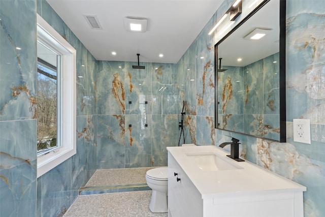 full bathroom with toilet, visible vents, vanity, and tile walls