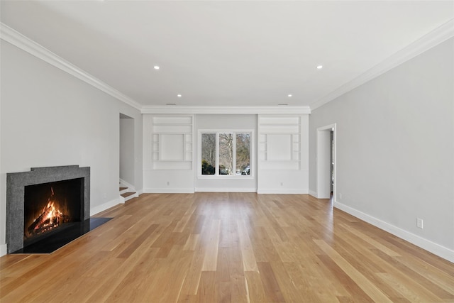 unfurnished living room with light wood-type flooring, a fireplace with flush hearth, baseboards, and crown molding