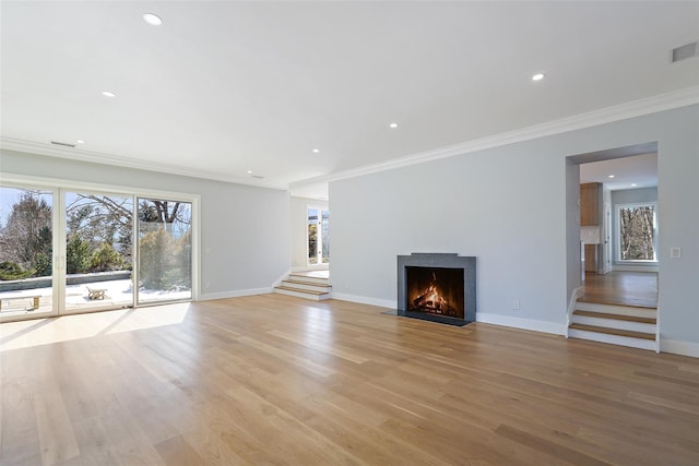 unfurnished living room with stairway, ornamental molding, and light wood finished floors