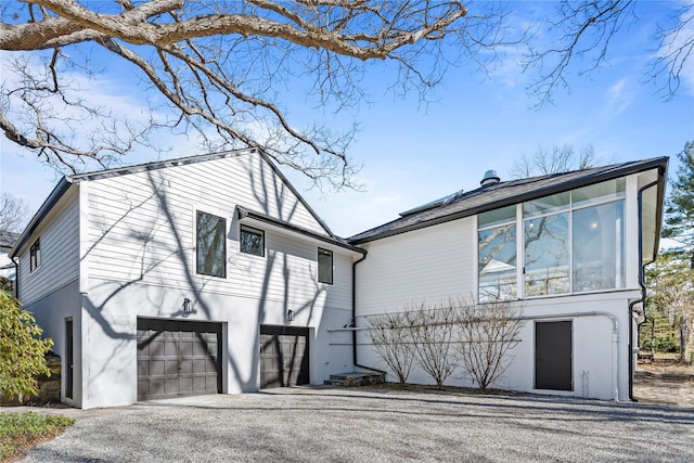 view of front of home with stucco siding, aphalt driveway, and a garage