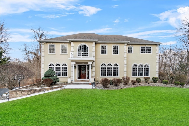 view of front of house featuring a balcony and a front lawn