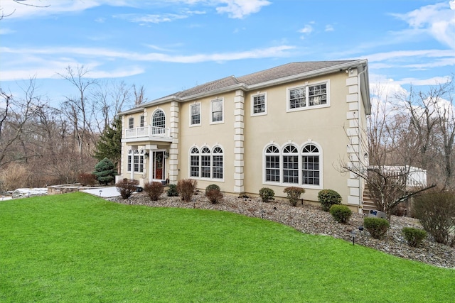 exterior space featuring a balcony and a front yard