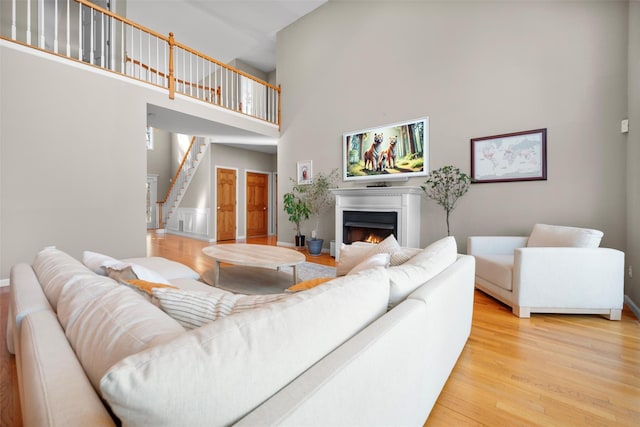 living room with a high ceiling and light hardwood / wood-style floors