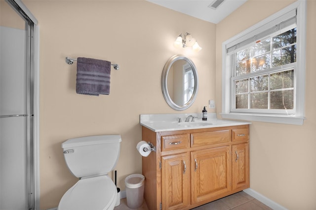 bathroom with toilet, vanity, and tile patterned floors