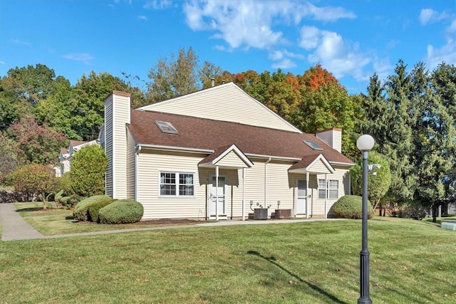 view of front of home with central AC and a front lawn