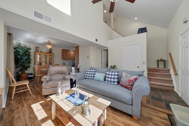 living room with wood-type flooring, high vaulted ceiling, and ceiling fan