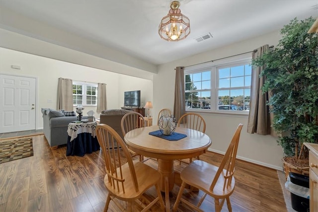 dining room featuring a chandelier, a wealth of natural light, and wood-type flooring