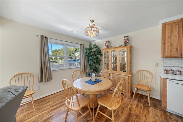 dining area with hardwood / wood-style floors and a notable chandelier