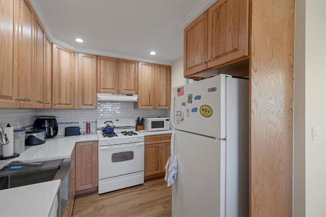 kitchen with light wood-type flooring, white appliances, and tasteful backsplash