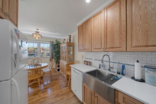 kitchen with decorative backsplash, white appliances, sink, and a chandelier