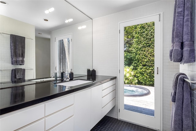 bathroom featuring tile patterned floors, vanity, and tile walls