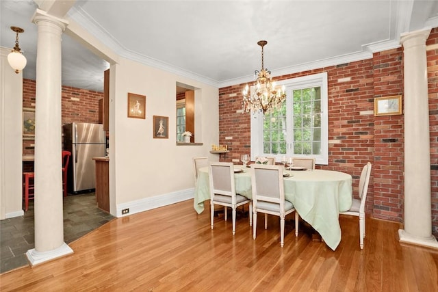 dining space featuring hardwood / wood-style flooring, crown molding, brick wall, and an inviting chandelier