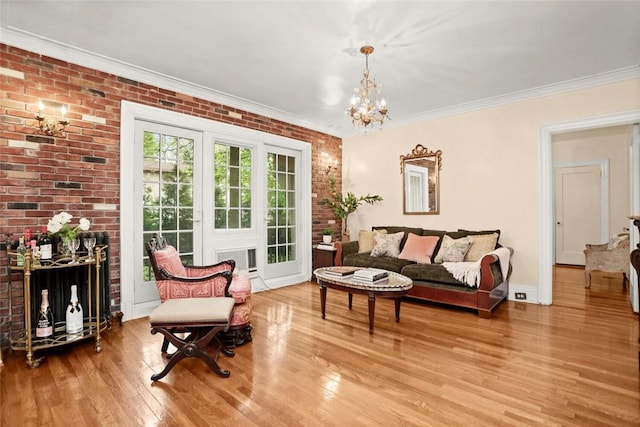 living room with light wood-type flooring, an inviting chandelier, crown molding, and brick wall