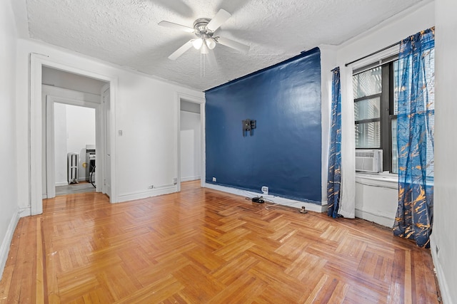 empty room featuring cooling unit, ceiling fan, parquet floors, and a textured ceiling