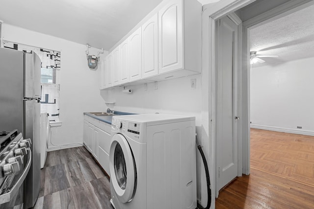 laundry room featuring a textured ceiling, ceiling fan, sink, washer / clothes dryer, and dark hardwood / wood-style floors