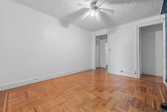 unfurnished bedroom with ceiling fan, dark parquet flooring, and a textured ceiling