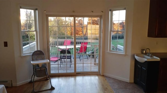 entryway featuring sink, a baseboard radiator, and light hardwood / wood-style flooring