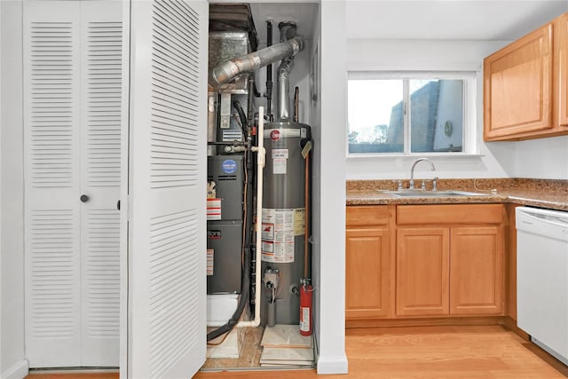 kitchen with gas water heater, sink, white dishwasher, light brown cabinets, and light wood-type flooring